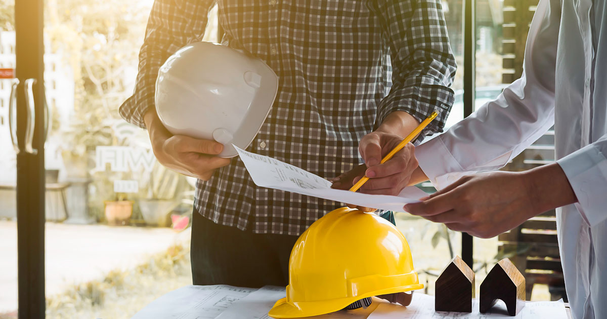 Construction NVQ Guide: Construction holding a hard hat