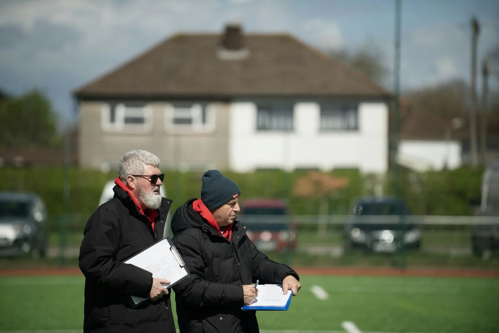 A couple of men standing next to each other on a field