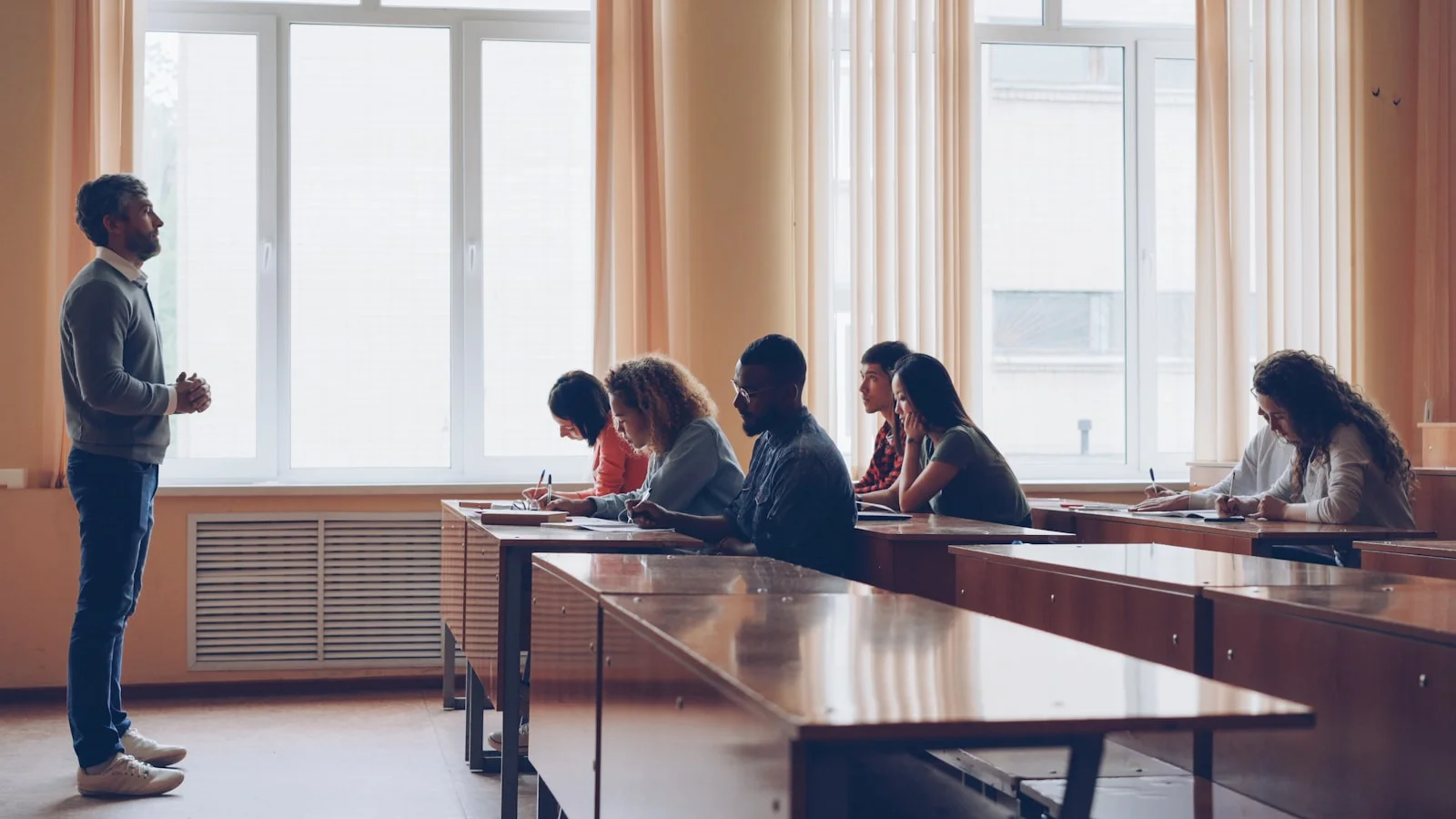 Teacher lecturing students in a classroom setting. Teacher lecturing students in a classroom setting.
